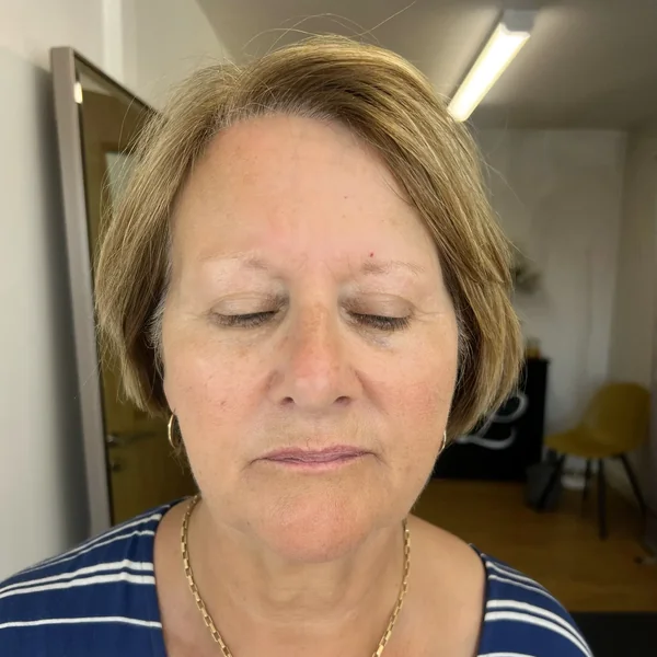 Uneven brow shape on mature blonde client before correction by Lorraine