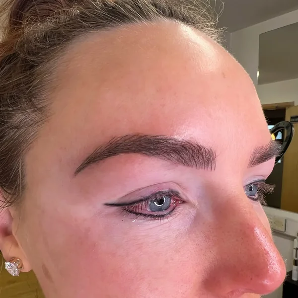 Bare lash line on mature freckled client before semi-permanent eyeliner tattoo