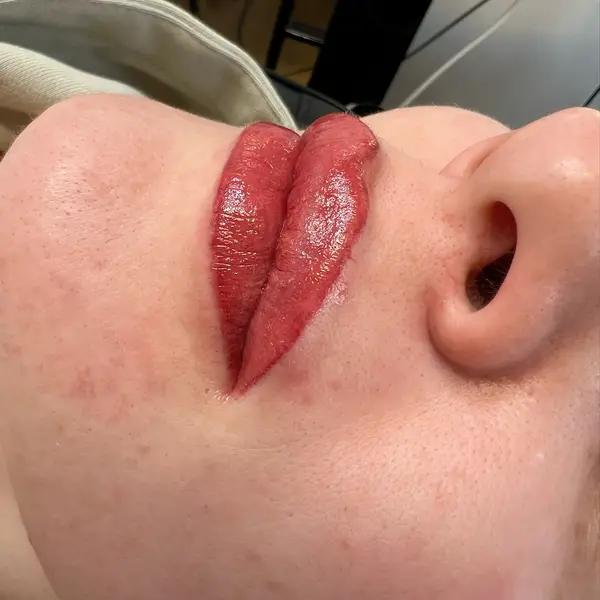 Cosmetic lip tattoo result — rich red, close-up showing cupid's bow definition
